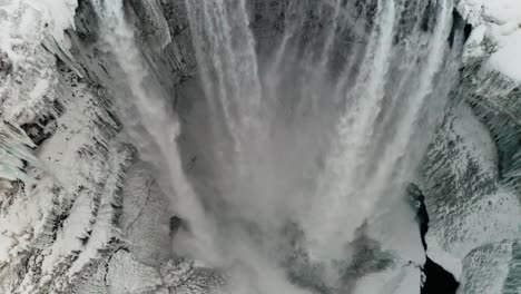 Ein-Wunderschöner-Großer-Wasserfall-In-Island-Mitten-Im-Winter,-Bedeckt-Von-Schnee-Und-Den-Wolken,-Macht-Es-Noch-Besser