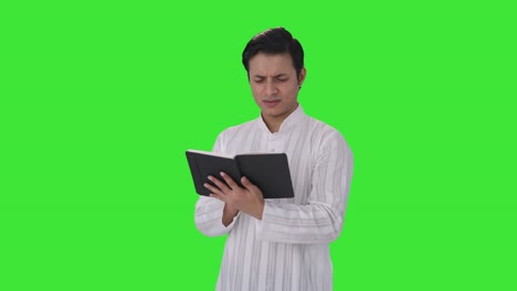 confused indian man reading a book green screen