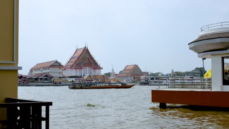 boat traveling along river near traditional buildings in bangkok thailand