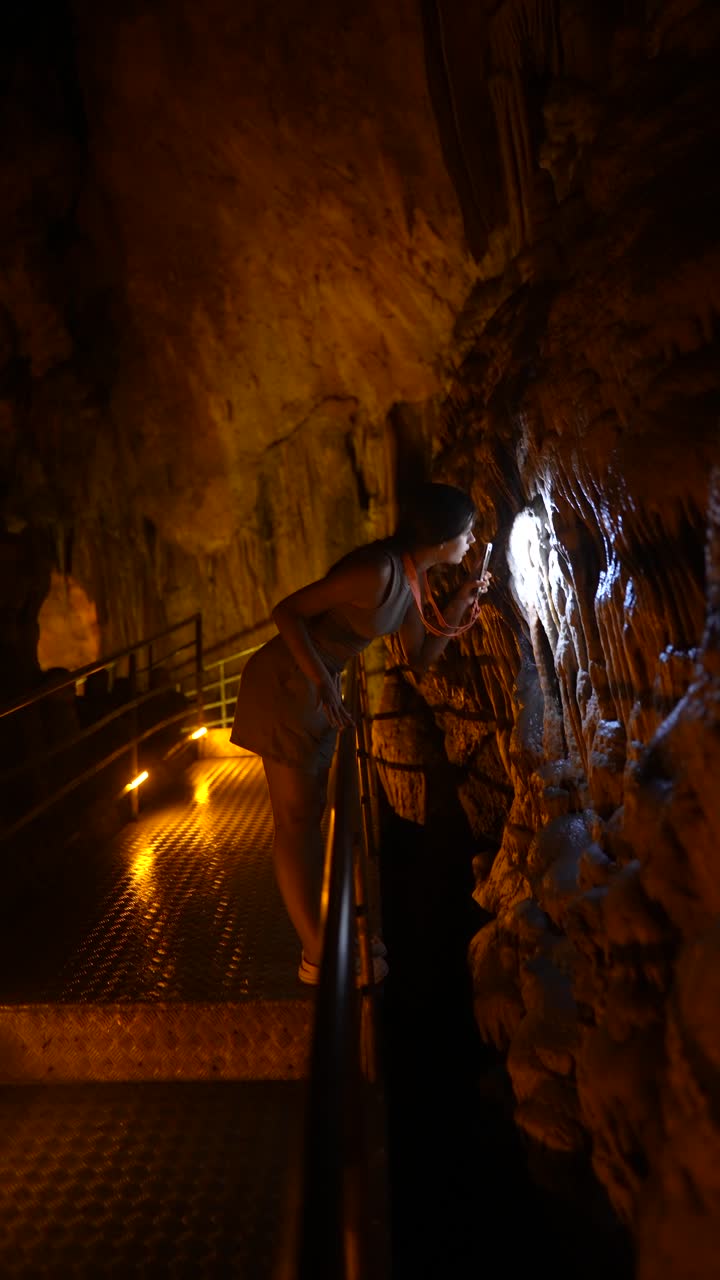Woman Exploring a Cave with a Flashlight