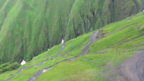 drone shot of vehicle driving on the road to tusheti, one of the worlds most dangerous roads