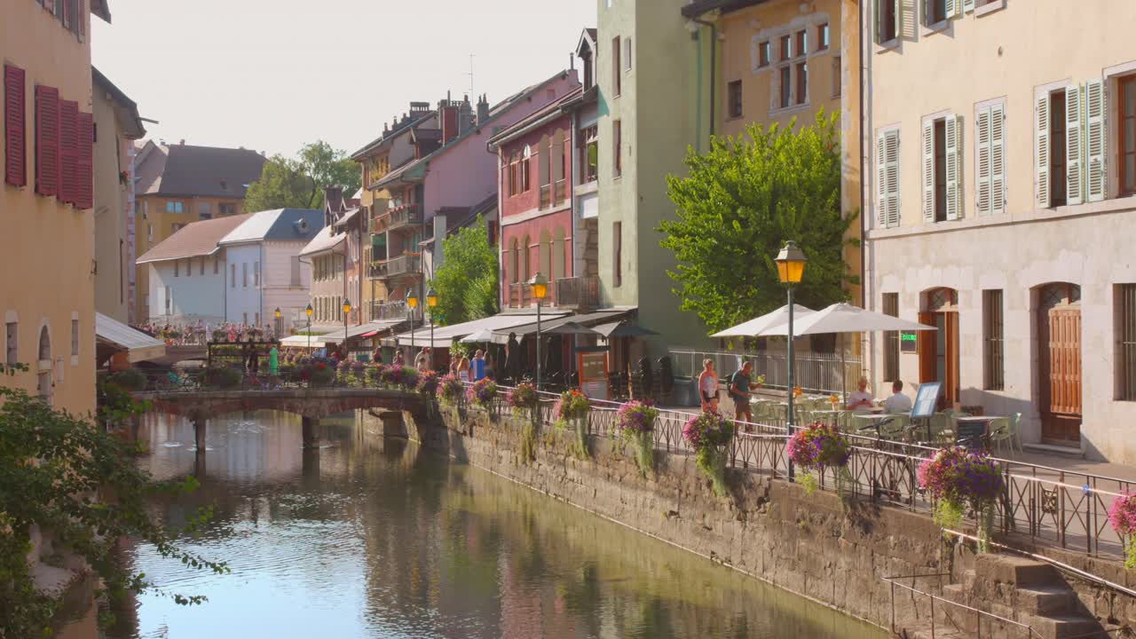 Charming riverside scene of colorful buildings and outdoor cafes in the old town of Annecy, France