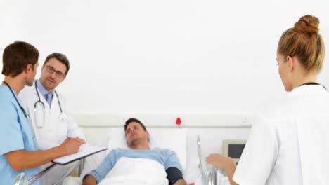 Ärzte-Sprechen-Mit-Kranken-Patienten-Im-Bett,-Während-Die-Krankenschwester-Die-Nadel-Vorbereitet