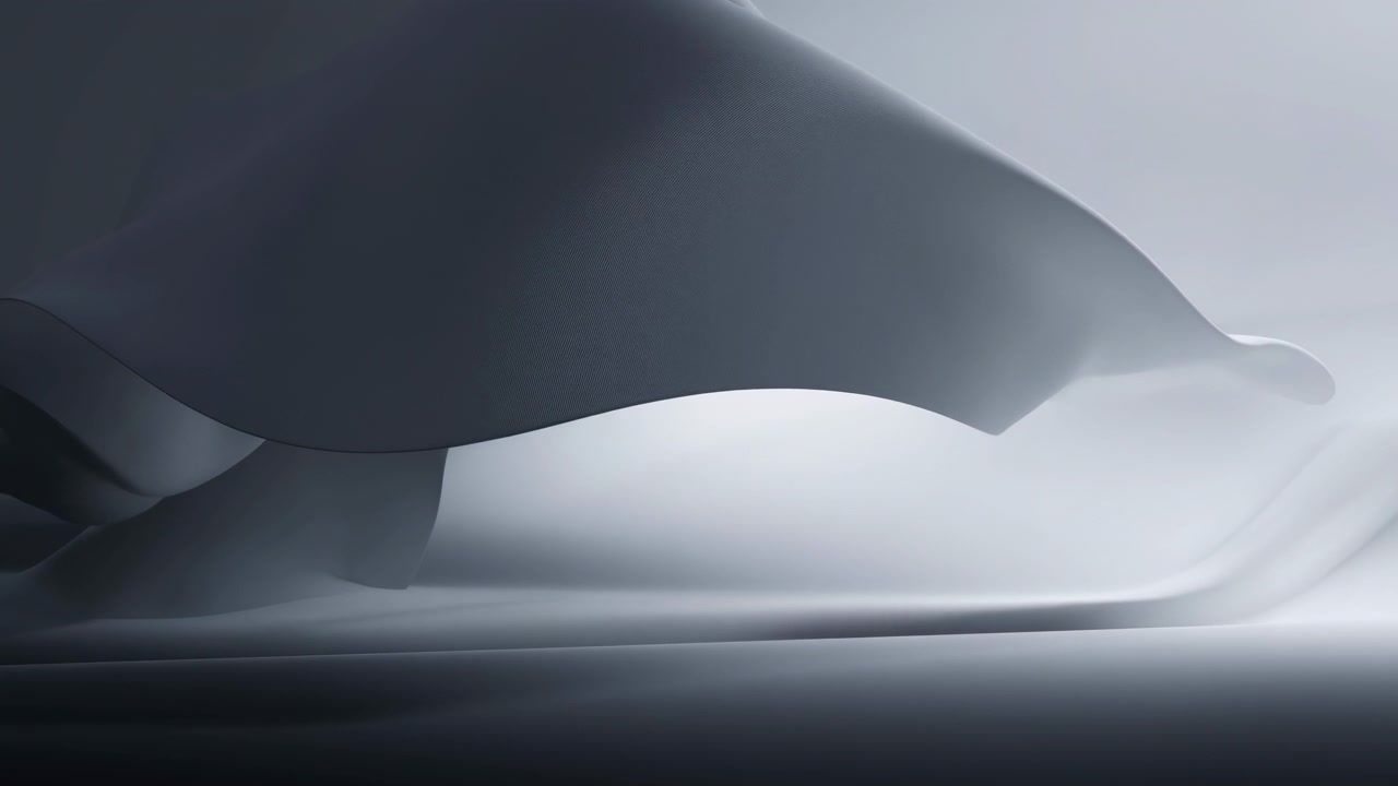 Una superficie astratta scura simile a tessuto scivola orizzontalmente con un movimento delicato, rivelando curve stratificate e ombre morbide su un terreno liscio sotto un'illuminazione sottile in un ambiente minimalista monocromatico.