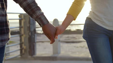 mid section of couple walking with hand in hand on promenade 4k