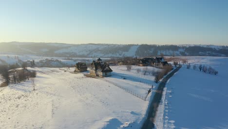 Paisaje-Invernal-Del-Pueblo-Polaco:-Visión-Aérea-De-Carreteras-Y-Casas-Iluminadas-Por-El-Sol