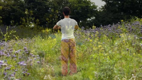 hombre haciendo yoga en el campo de flores