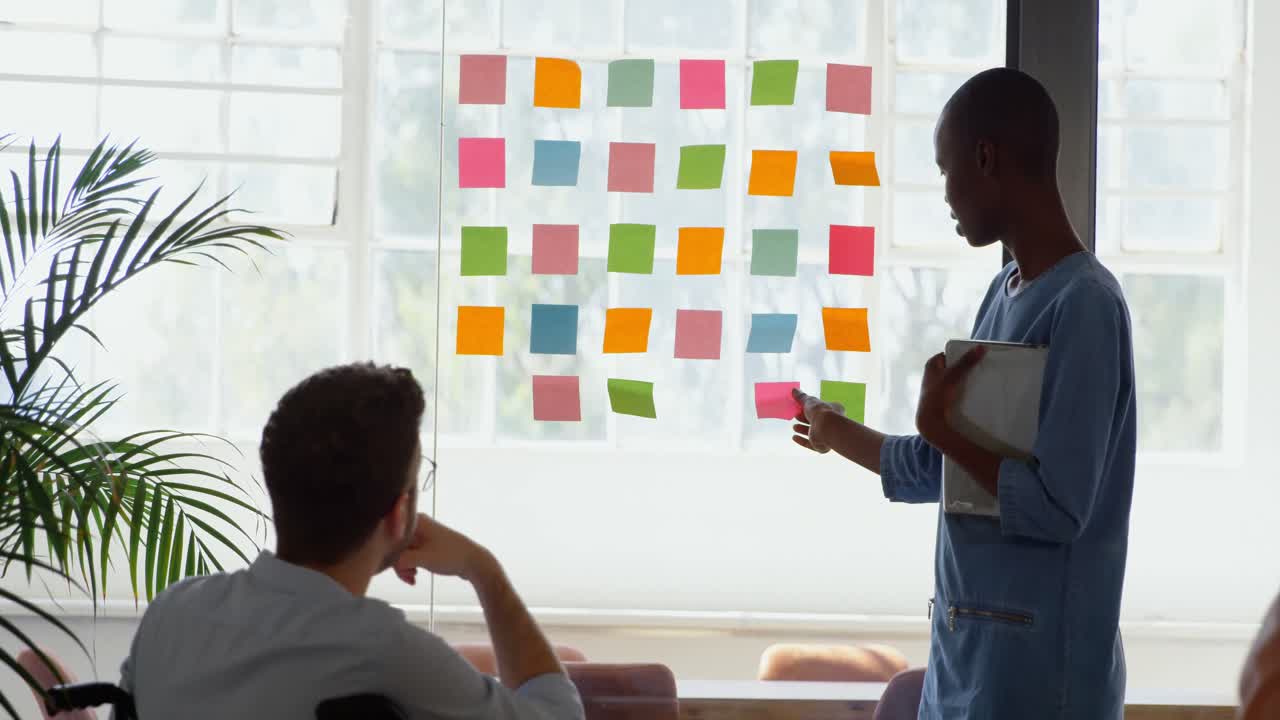 Side view of young mixed-race business team planning and working in a modern office 4k