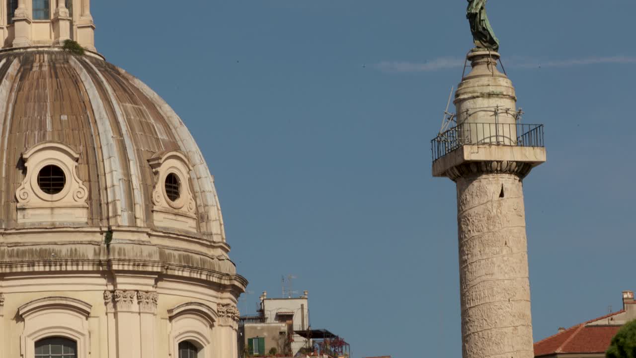 로레토 돔의 성모 마리아 교회와 상단의 성 페트로 동상에 있는 트라야누스의 기둥을 가까이서 촬영하십시오.