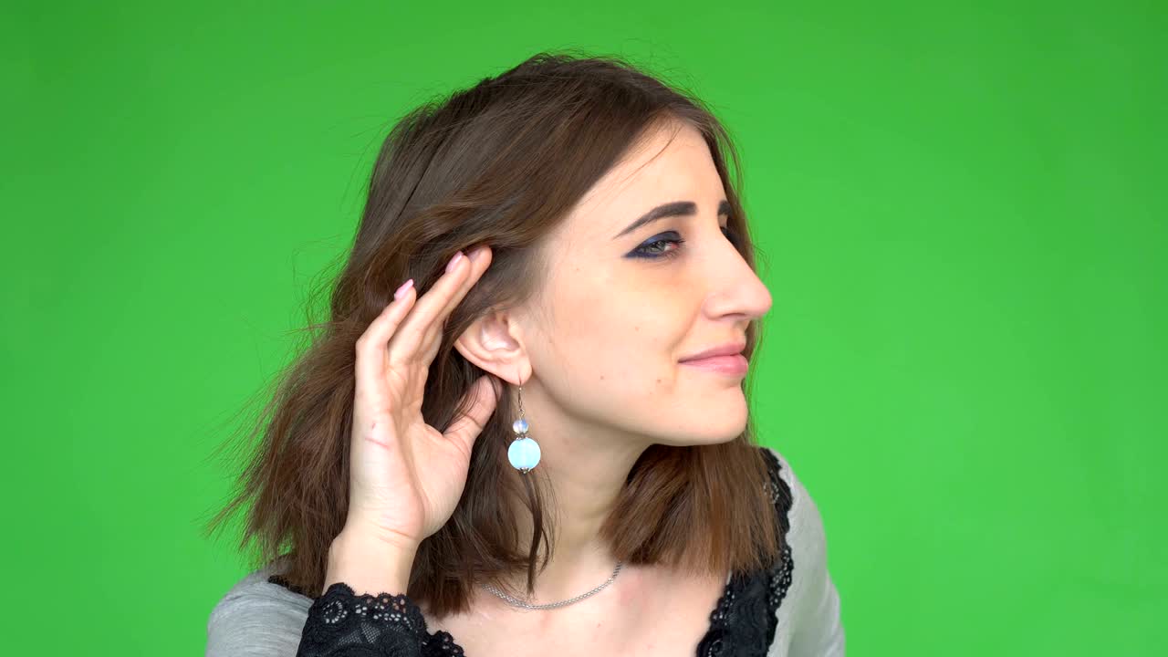 Surprised young nosy woman hand to ear gesture intently listening juicy gossip conversation news.