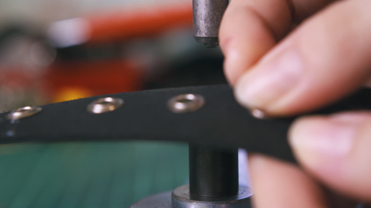 sastre profesional establece piezas de ojo con máquina de prensa