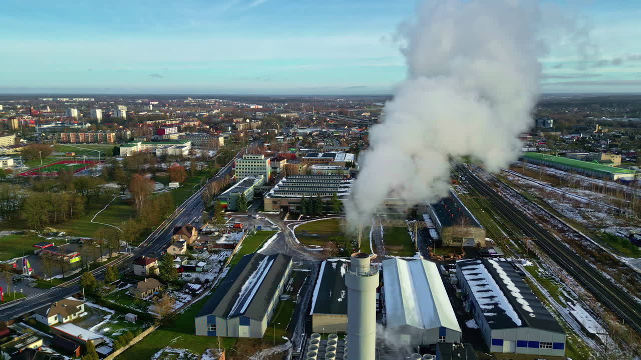 vista aerea di un paesaggio cittadino e di un'area industriale con fumo che esce dal camino