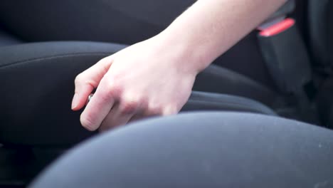 Slow-motion-shot-of-driver-using-hand-to-pull-up-parking-handbrake-level-shift-in-car-safety-transport-system-motor-vehicle-console-transmission