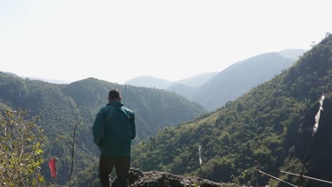mawryngkhang trek meghalaya india에서 평평한 각도의 비디오에서 아침에 녹색 숲과 안개 낀 푸른 하늘이 있는 산 정상에 있는 고립된 청년