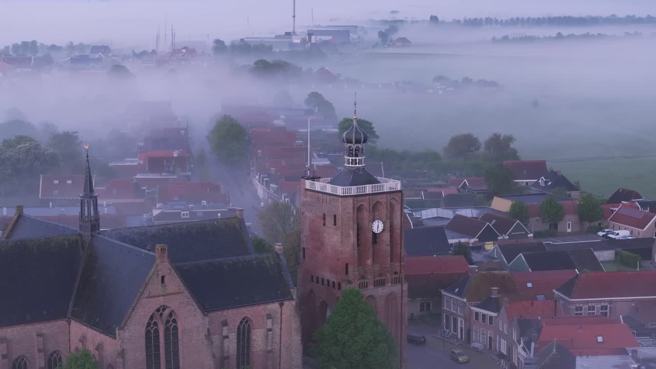 Tåget Workum by med kirke ved solopgang, Holland