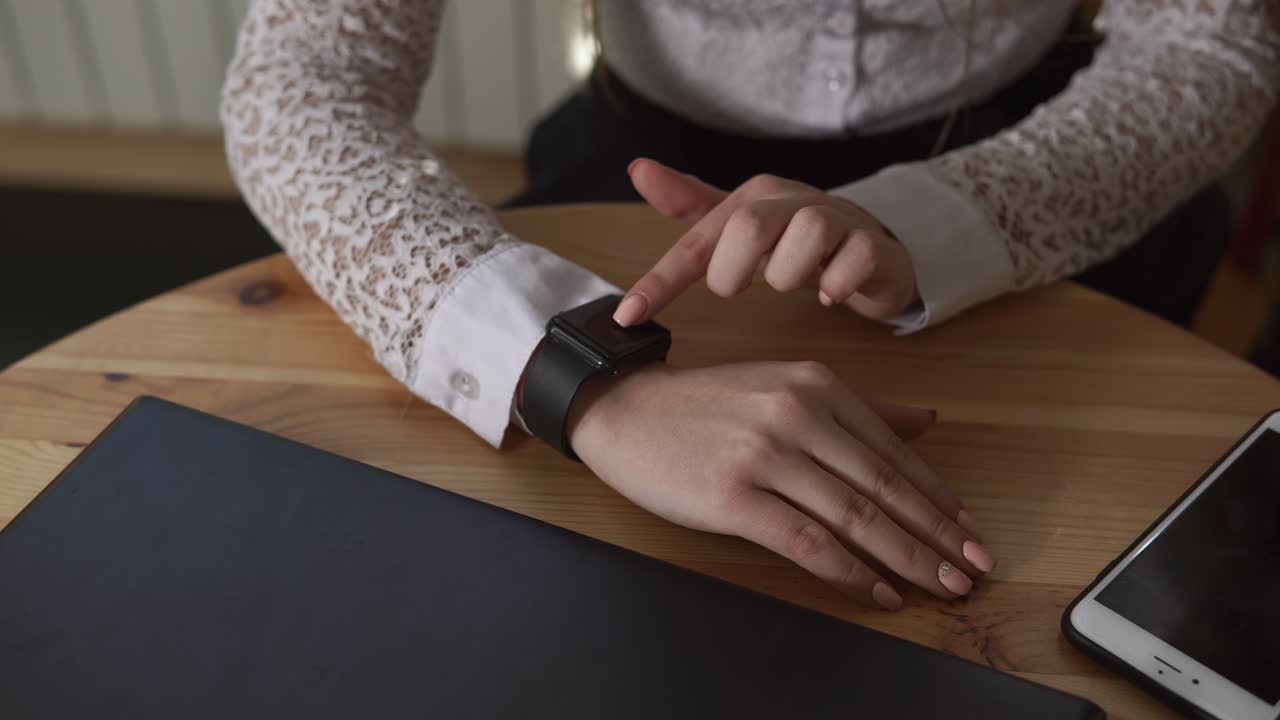Woman Using Smartwatch at Cafe Table