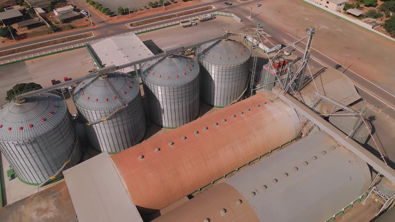 Complexo agrícola industrial com grandes silos de grãos de metal e armazéns de armazenamento. Vista aérea de drone da moderna instalação de agronegócio.