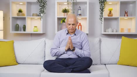 un anciano meditando en su casa.