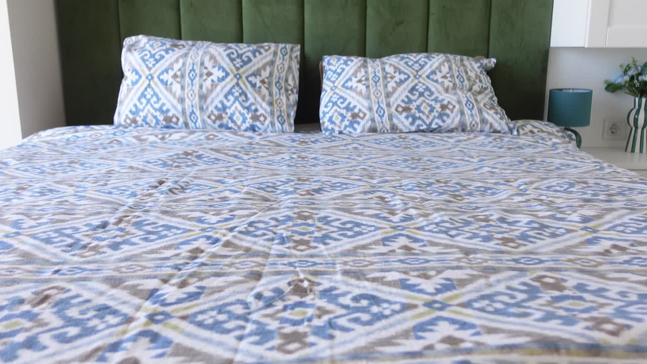 Bedroom with patterned bedding and green headboard
