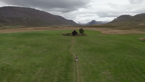 persona caminando hacia grafarkirkja en un día nublado