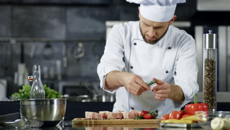 retrato de cocinero aderezando un filete en el lugar de trabajo de la cocina
