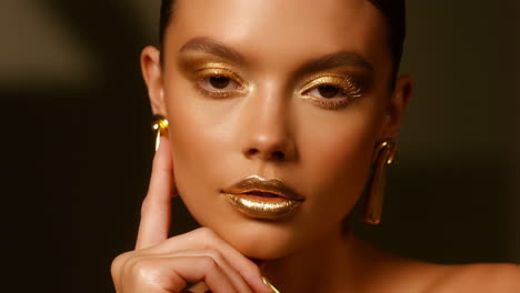 woman with striking gold makeup and accessories