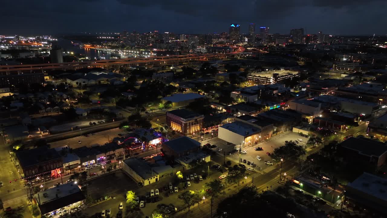 Night scene over America. City with lighting shops along Main Street in suburb. Traffic on Orange highway. Tampa town, Florida. USA. Aerial wide shot