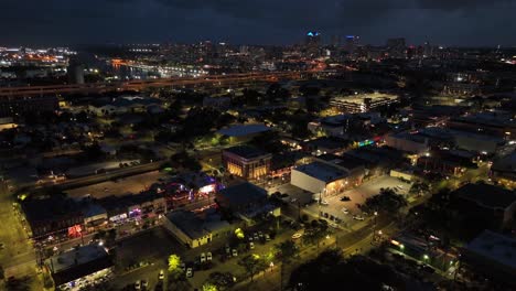 night scene over america. city with lighting shops along main street in suburb. traffic on orange highway. tampa town, florida. usa. aerial wide shot