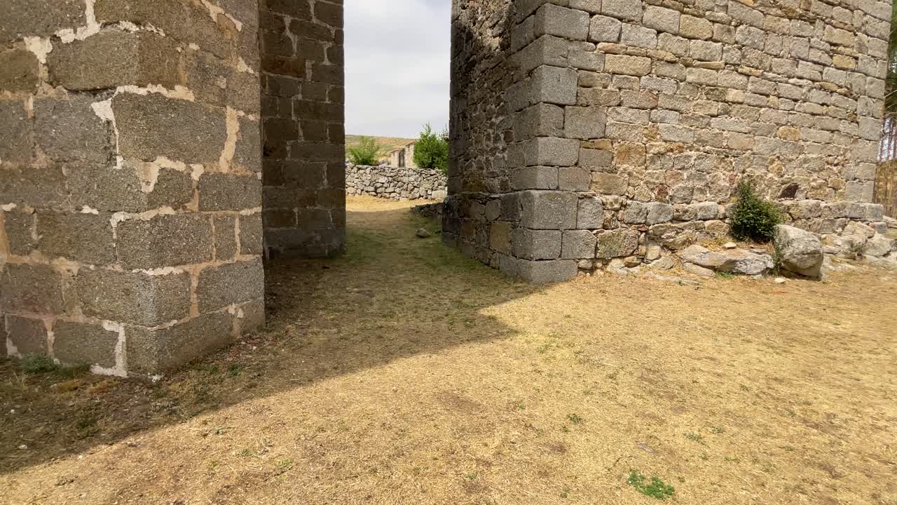 Filming of a small stone bell tower with its two holes for the bells and separated by a corridor is a medieval sanctuary, we appreciate its robust carved stone buttresses, all in slow motion