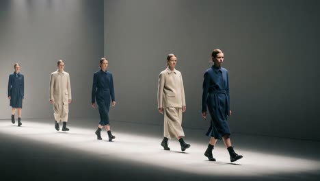 a modern fashion runway show featuring minimalist designs in monochrome color palettes, highlighting innovative textures and contemporary styles
