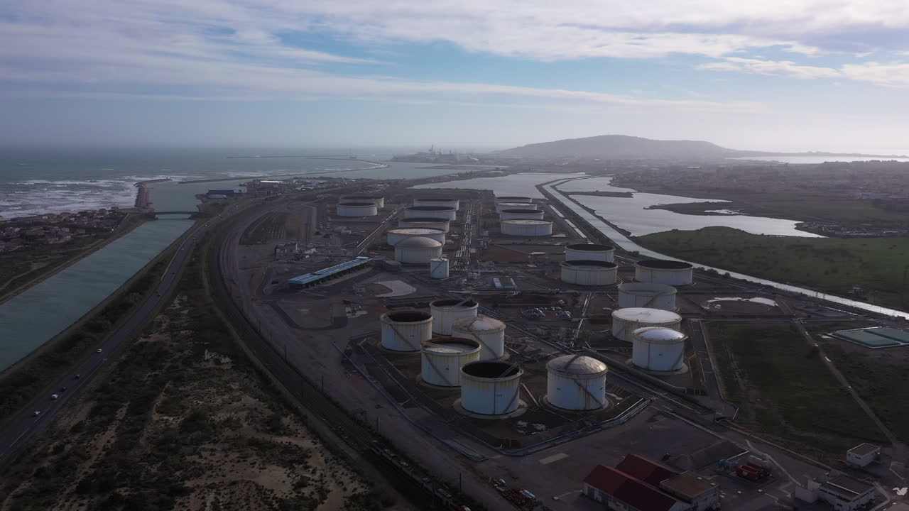 배경에 있는 석유 가스 저장소 세테 위의 드론 풍경. 해안 운하