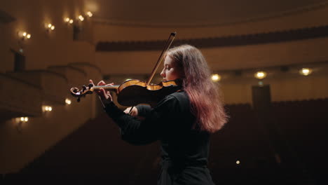 Porträt-Einer-Hübschen-Geigenspielerin-Im-Opernhaus.-Eine-Geigerin-Spielt-Geige-Im-Musiksaal