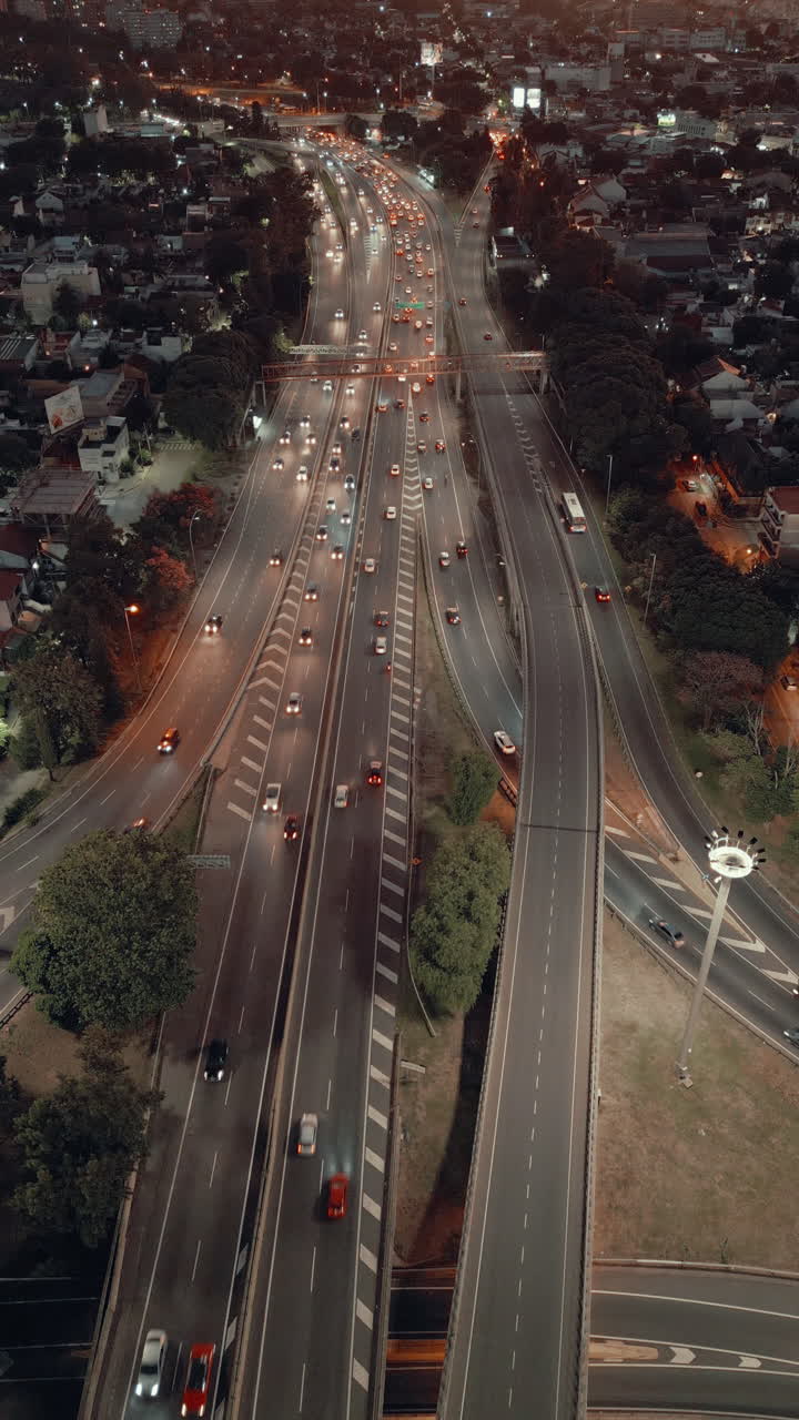 Vista aerea di un trafficato svincolo autostradale urbano al tramonto con veicoli in transito