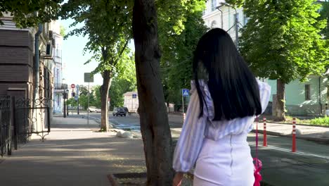 Stylish woman with long hair talk on phone walking at urban street
