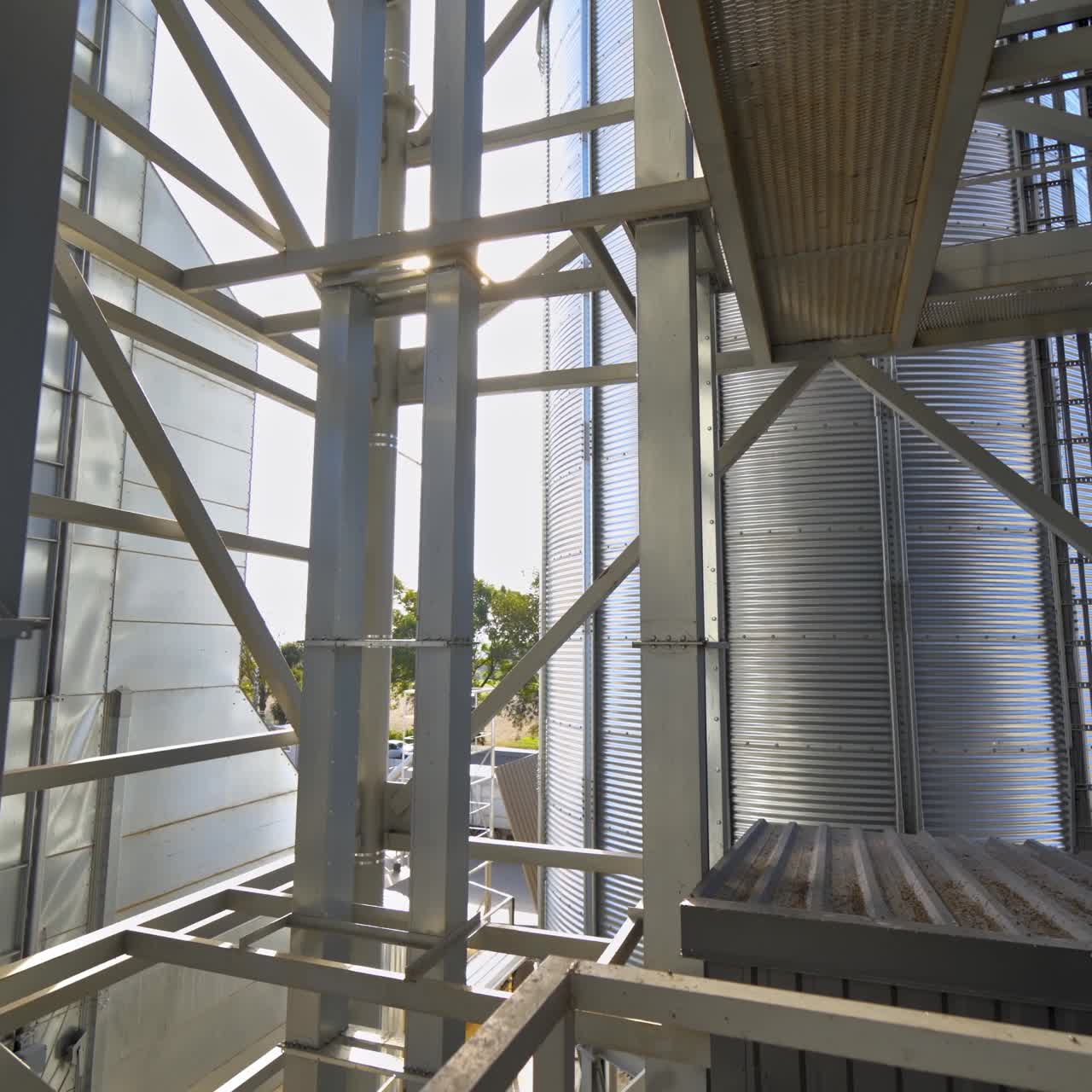 Modern warehouse. Metal frame on industrial plant. Grain elevator. Storage tanks with metal equipment outdoors.