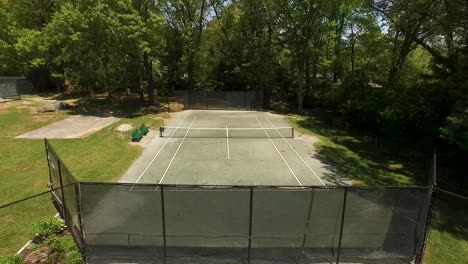 rotating aerial shot of an empty tennis court on a sunny summer day
