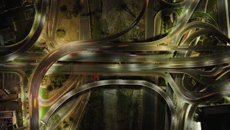 aerial motion time-lapse above cars in a lit intersection, nigttime in mexico - birds eye, drone shot