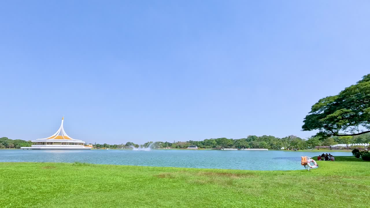 방의 라마 ix 파크에서 조용한 장면, 울창한 초록색, 호수, 그리고 은 파란 하늘 아래의 먼 파빌리온