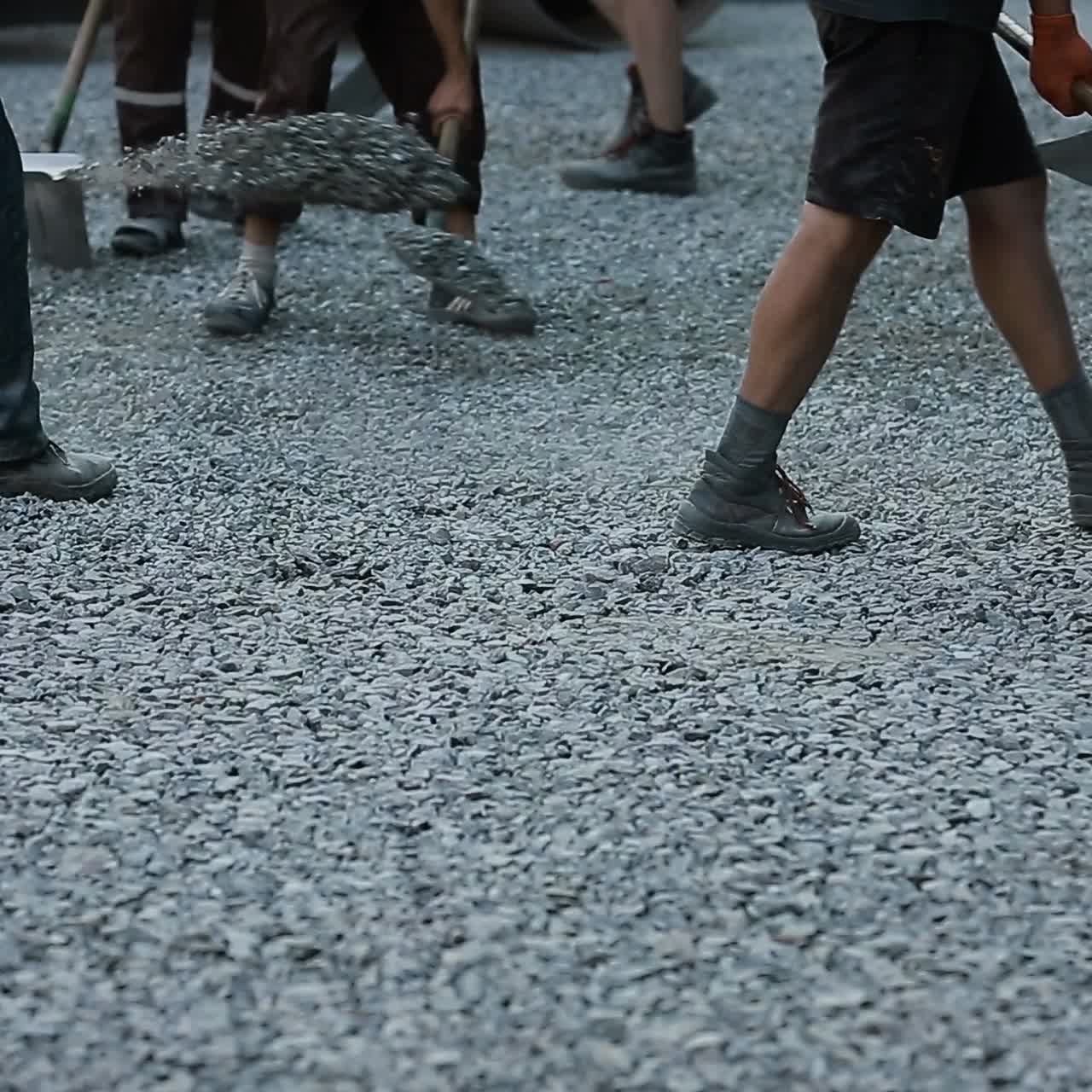 los trabajadores lanzan grava con palas