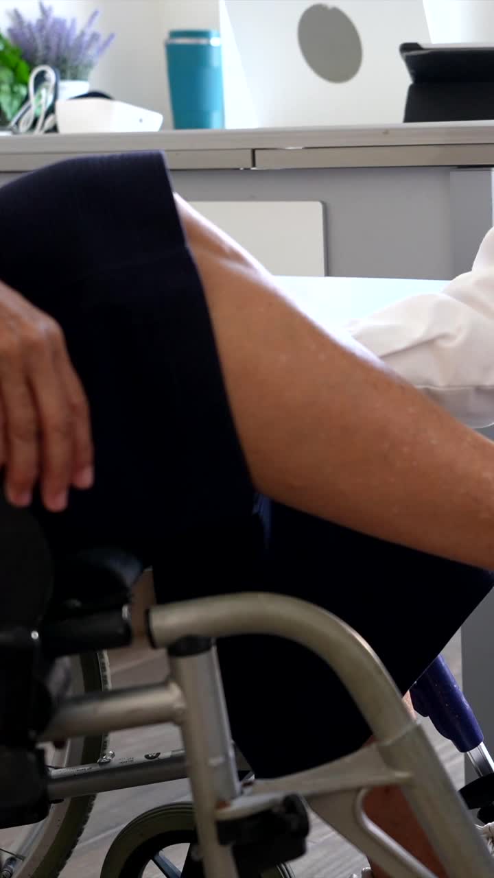 Doctor assisting patient in wheelchair