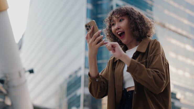 Glad kvinde bruger telefon i byen