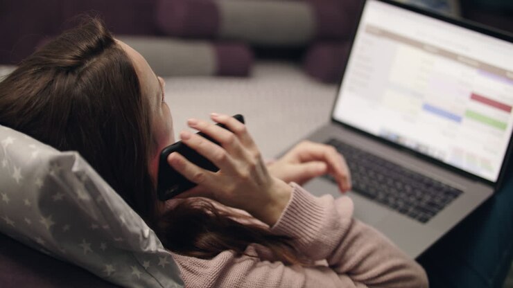 Business woman call mobile phone while working on laptop