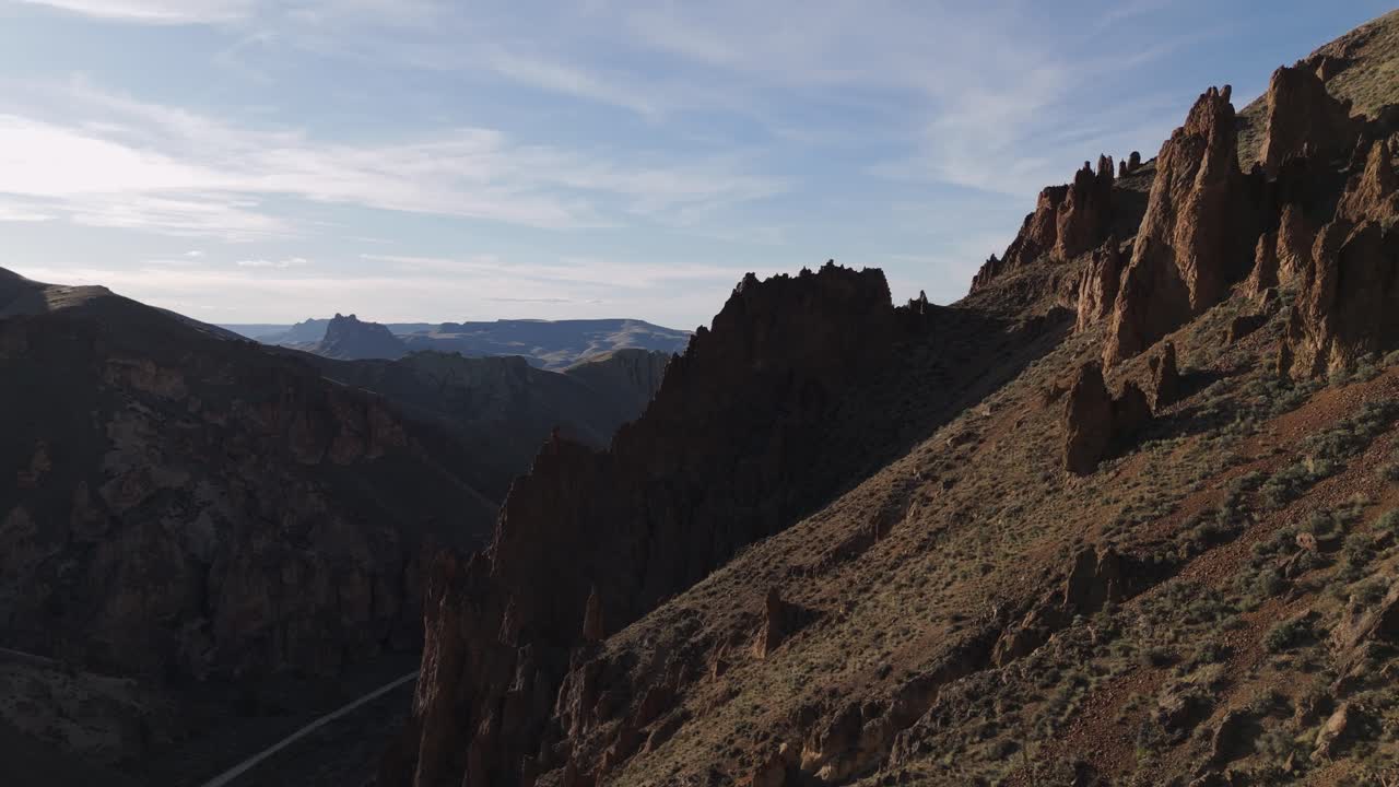 el seguimiento de drones de derecha a izquierda a lo largo de la ladera empinada en leslie gulch, oregon, para revelar todo el cañón y la carretera al atardecer.