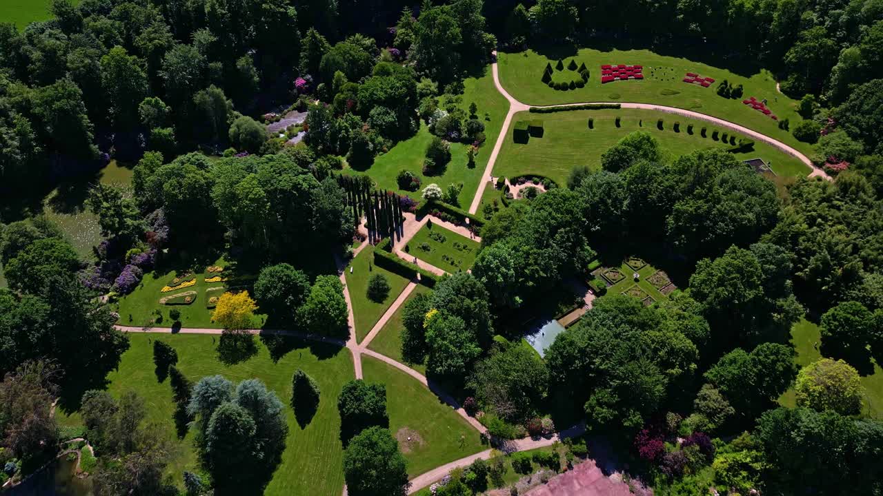 Beautiful garden layout at Upper Brittany Botanical Park surrounded by dense trees from above, Le Chatellier, France.