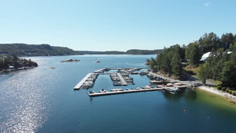 Boats-in-harbour-in-blue-coastal-water,-aerial-summer-view