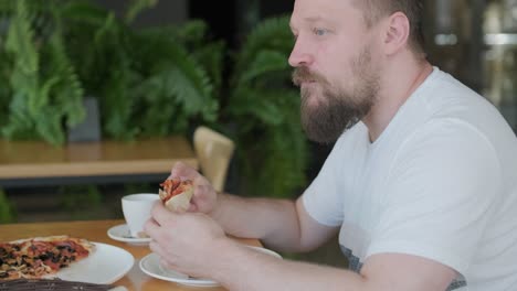 man eating pizza in a cafe