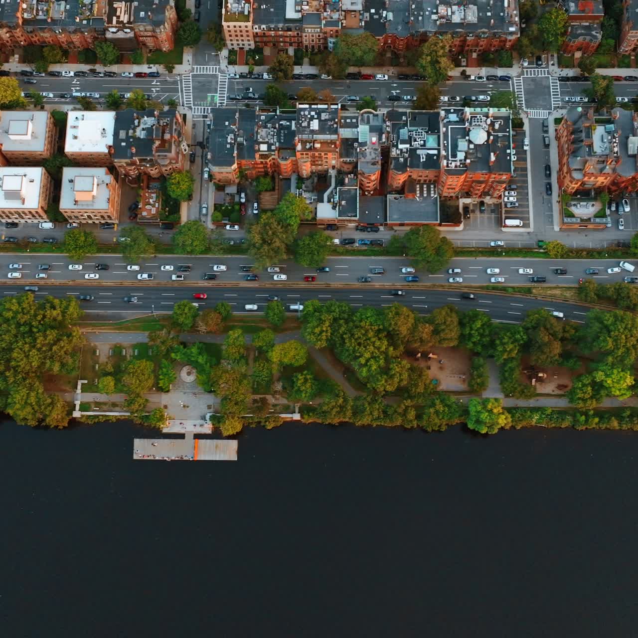 Highways with busy traffic on the bank of the Charles River in Boston, USA. Bird's eye view on the waterfront and buildings' tops
