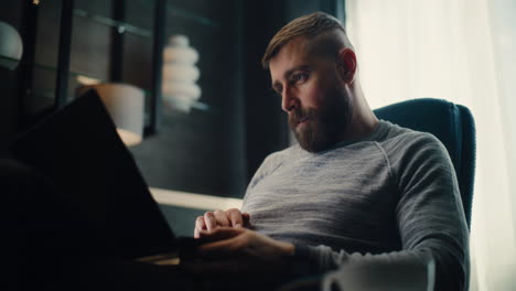professional stock exchange broker talking on phone, analyzing real-time stocks and exchange market charts using laptop computer. successful investment agent works in cozy office of financial agency.