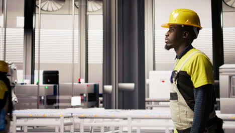 vertical video man walking in industry 4.0 plant, taking note of modifications to make