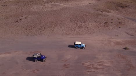 Jeeps-are-cruising-on-dirt-road-at-mount-bromo-active-vulcano,-aerial